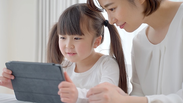 タブレットを使う女の子と母親