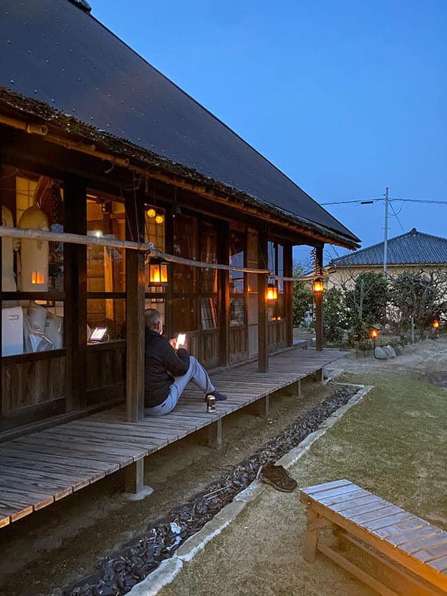 ランプが照らされている縁側でくつろぐ男性