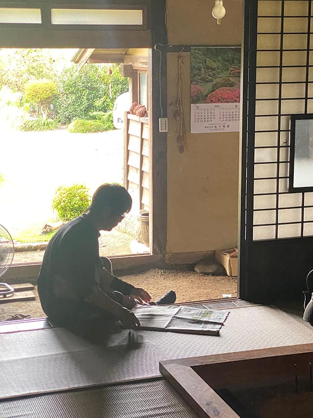 玄関で新聞を読む男性