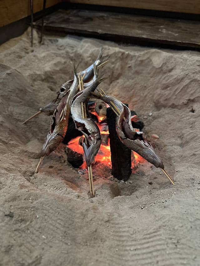 囲炉裏で魚を焼いている様子
